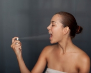 Woman spraying breath spray in her mouth
