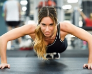 Young beautiful woman doing pushups in the gym. Girl wearing sportwears clothes.