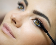 Woman applying mascara on her long eyelashes