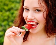 Beautiful young lady eating a strawberry