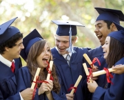 Graduating students smiling and laughing with diplomas