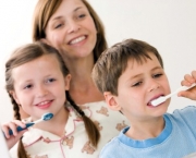 Mother watching children brushing teeth