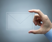 Human hand holding futuristic transparent mail icon