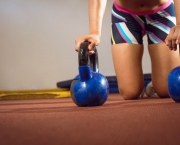 Fitness woman doing push ups with kettlebells
