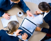 Image of three business people working at meeting