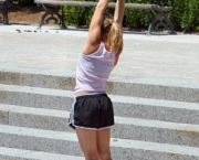 A young woman stretches for the sky before beginning her morning run in Forest Park, St Louis MO. 2007-06-09.