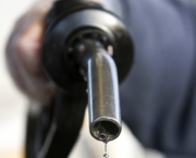 A customer holds a fuel pump at a petrol station in Harold Wood, Essex, U.K., on Friday, Dec. 5, 2008. European stocks fell, extending this weekâs decline, as a slump in commodity prices sent metal and energy producers lower and concern deepened the global economy is worsening. U.S. index futures were little changed. Photographer: Chris Ratcliffe/Bloomberg News