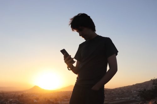 Jovem Olhando o Conteúdo de seu Smartphone 